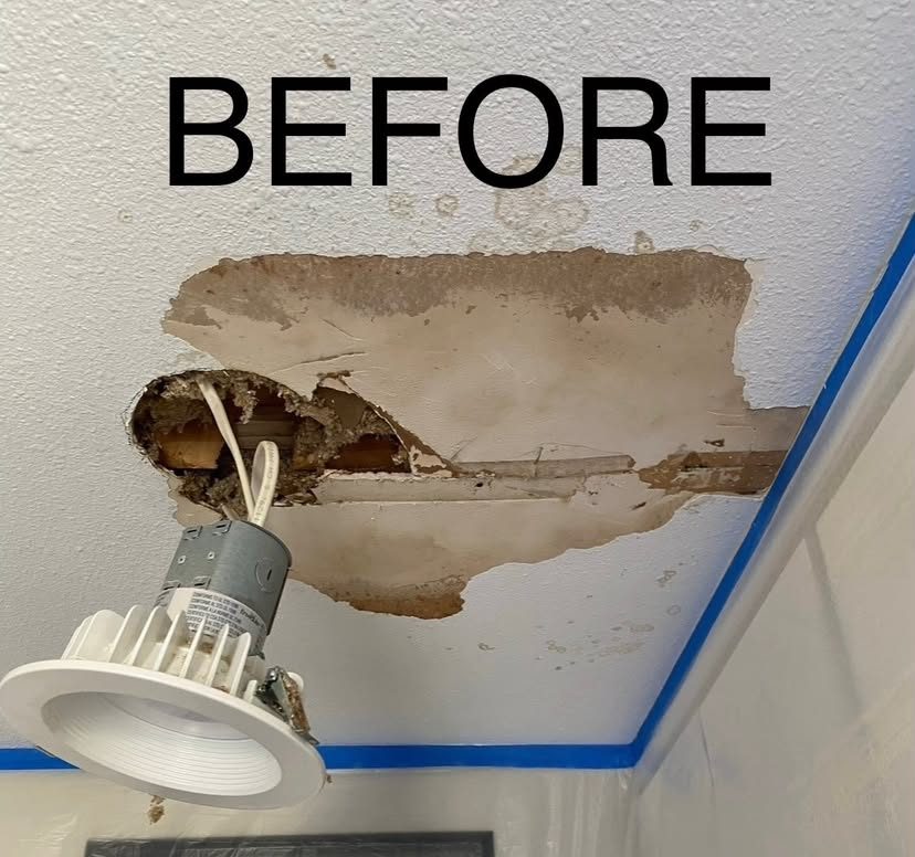 Ceiling around a recessed light with water staining and peeling paint, the fixture dropped out and the damaged area taped off