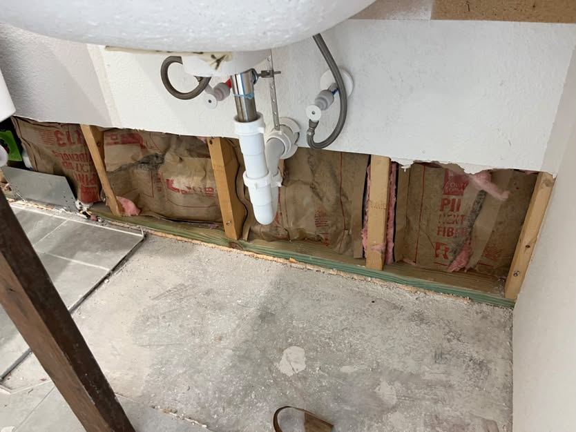 Wall under the sink opened to the studs and insulation